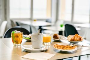 a table with plates of food and a glass of beer at Hotel La Corniche in Saint-Hilaire-de-Riez