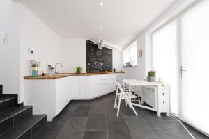 uma cozinha com armários brancos e um balcão com uma secretária em The Apartment Central em Mainz