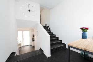 eine Treppe in einem Haus mit weißen Wänden und einem Holztisch in der Unterkunft The Apartment Central in Mainz