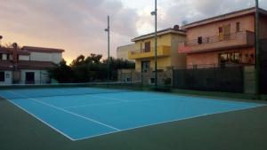 un campo da tennis di fronte a un edificio di Alex House a Cagliari
