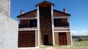 a house with two garage doors and a building at Hospedaje Herradura in San Miguel Regla