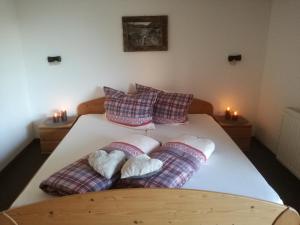 a bedroom with a bed with pillows and two candles at Häus`l am Ruan in Berwang