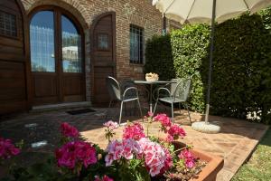 um pátio com uma mesa, cadeiras e flores em Podere Fontegallo em Castiglione del Lago