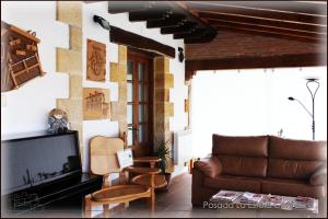 a living room with a couch and a tv at Posada La Estela Cántabra in Toñanes