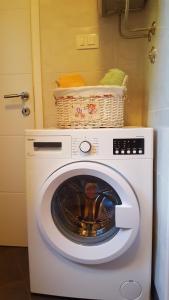 uma máquina de lavar roupa com um cesto em cima em Rogic Apartment em Lovran