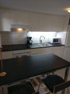 a kitchen with a sink and a microwave at Lägenhet Färjestaden in Färjestaden +7 photos