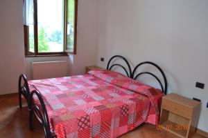 レードロにあるCasa Miravalleの赤いキルトが敷かれたベッドが備わる客室です。