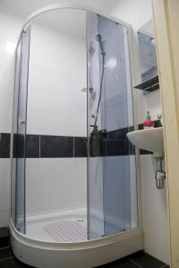 een douche met een glazen deur naast een wastafel bij Gorsad Apartment in Odessa