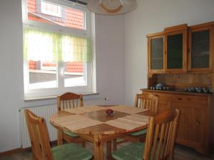 a kitchen with a wooden table and chairs and a window at Ferienwohnung Mack in Wernigerode +8 photos