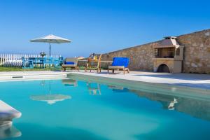 馬拉提的住宿－Crete View，一个带两把椅子和遮阳伞的游泳池