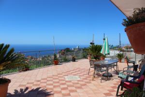 a patio with a table and chairs and the ocean at Dreams House in Agerola