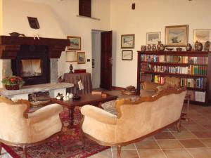 sala de estar con 2 sillas y chimenea en B&B Castello di Camerletto, en Caselette