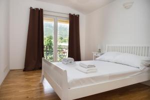 een wit bed in een kamer met een raam bij Villa Mira in Kaštela