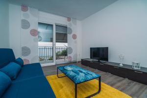 a living room with a blue couch and a tv at Apartmani Josip in Podstrana