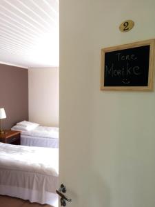 a room with two beds and a chalkboard on the wall at UusAllika Puhkemaja in Haapsalu