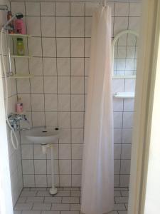 a bathroom with a shower curtain and a sink at UusAllika Puhkemaja in Haapsalu
