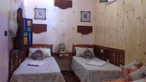 2 camas en una habitación con paredes de madera en Dar Yassir, en Chefchaouen