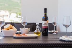 drewniany stół z butelką wina i kieliszkami do wina w obiekcie Apartment Marija 2 near Split w mieście Kaštela