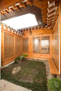 Großes Zimmer mit Holzwänden und einem großen Fenster in der Unterkunft Bukchonae in Seoul