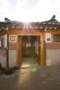 einen Eingang zu einem Gebäude mit leuchtender Sonne in der Unterkunft Bukchonae in Seoul