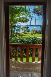 een raam met uitzicht op de oceaan vanuit een resort bij Porto dos Casais Guest House Itacaré in Itacaré