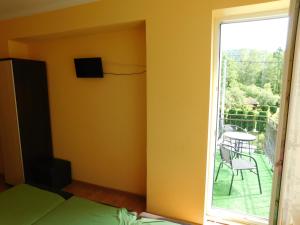 Cette chambre dispose d'un lit et d'une fenêtre avec une terrasse. dans l'établissement Pokoje Gościnne Dastin, à Ustroń