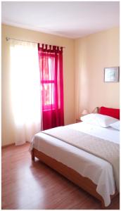 a bedroom with a bed and a red window at Apartmani Biočić in Split