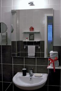 W łazience znajduje się umywalka i lustro. w obiekcie Trident Apartments w Niszu