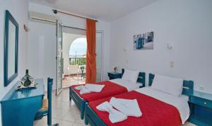 パティティリにあるStudios Nelli Alonissosのベッドルーム1室(赤いシーツと白い枕のベッド2台付)