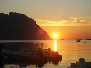 a group of boats in the water at sunset at Villa Raffaello in Porto San Paolo