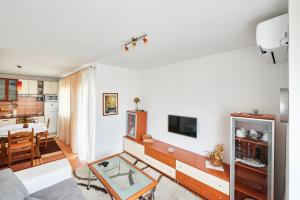 ein Wohnzimmer mit einem Sofa und einem Tisch in der Unterkunft Sv. Ilija Apartment - Vila Biokova in Baška Voda