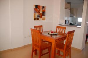a kitchen with a wooden table and four chairs at Golf Course View Penthouse in El Romero