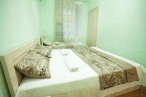 a large bed in a white room with two pillows at Apartment in Old Tbilisi Orbeliani Square in Tbilisi City