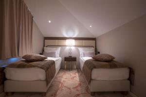 a hotel room with two beds and a window at Hotel Riva by Aycon in Petrovac na Moru