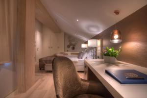 a bedroom with a bed and a desk with a chair at Hotel Riva by Aycon in Petrovac na Moru