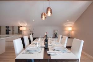 a dining room with a white table and white chairs at Hotel Riva by Aycon in Petrovac na Moru