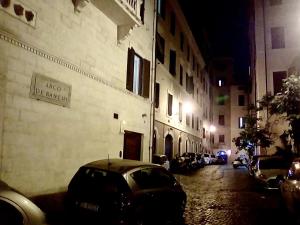 ローマにあるRonda St. Angelo Suitesの夜間の建物前に停車する車