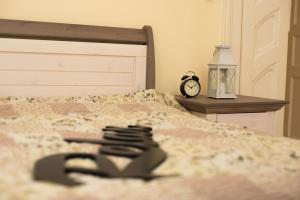 a close up of a bed with a clock on a table at Rox Central Apartments 2 in Timişoara