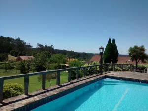 a swimming pool in a villa with a fence at Casa Bartulo in Castrofeito