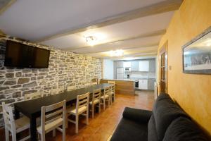 ein Esszimmer mit einer Steinmauer sowie einem Tisch und Stühlen in der Unterkunft Casa Borruel in Torla-Ordesa