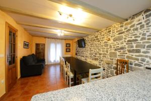 ein Wohnzimmer mit einer Steinmauer und einem Tisch in der Unterkunft Casa Borruel in Torla-Ordesa