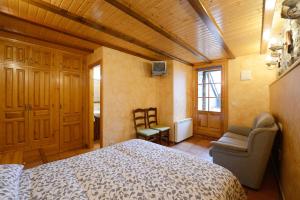um quarto com uma cama e uma cadeira num quarto em Habitación El Mirador Casa Cajal em Torla