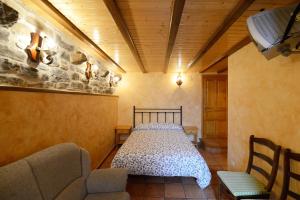 ein Schlafzimmer mit einem Bett in einem Zimmer mit einem Sofa in der Unterkunft Habitación El Mirador Casa Cajal in Torla-Ordesa