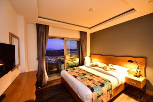 a hotel room with a bed and a large window at Degirmenburnu Residence in Bodrum City