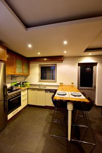 a kitchen with a wooden table with two bar stools at Degirmenburnu Residence in Bodrum City