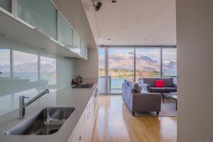 a living room filled with furniture and a large window at Swiss-Belsuites Pounamu Queenstown in Queenstown