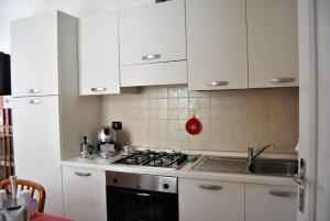 a kitchen with white cabinets and a stove top oven at Il Ciclamino Bed and Breakfast in Ascoli Piceno