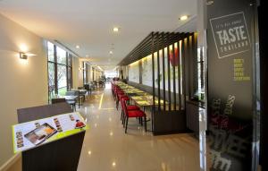 a restaurant with tables and chairs in a building at Ibis Bangkok Riverside in Bangkok
