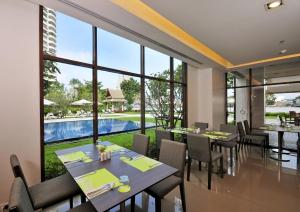 a dining room with large windows and a pool at Ibis Bangkok Riverside in Bangkok