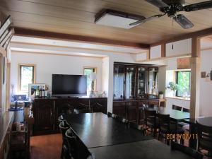 a dining room with a table and a flat screen tv at Lake Oshino in Oshino